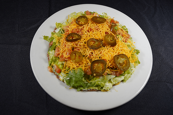 Taco salad with lettuce, tomatoes, jalapenos, and shredded cheese