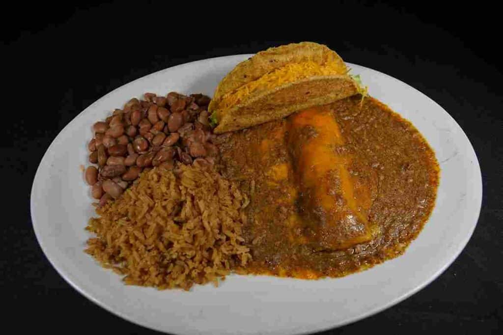 A plate of rice and beans topped with a taco