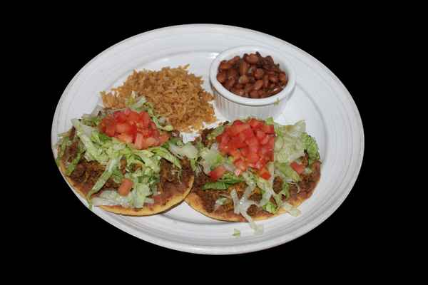 Tostadas with rice, beans, lettuce, cheese, and tomatoes