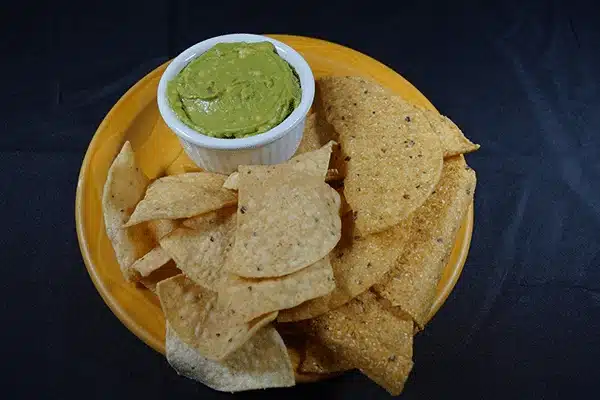 Plate of tortilla chips and green sauce