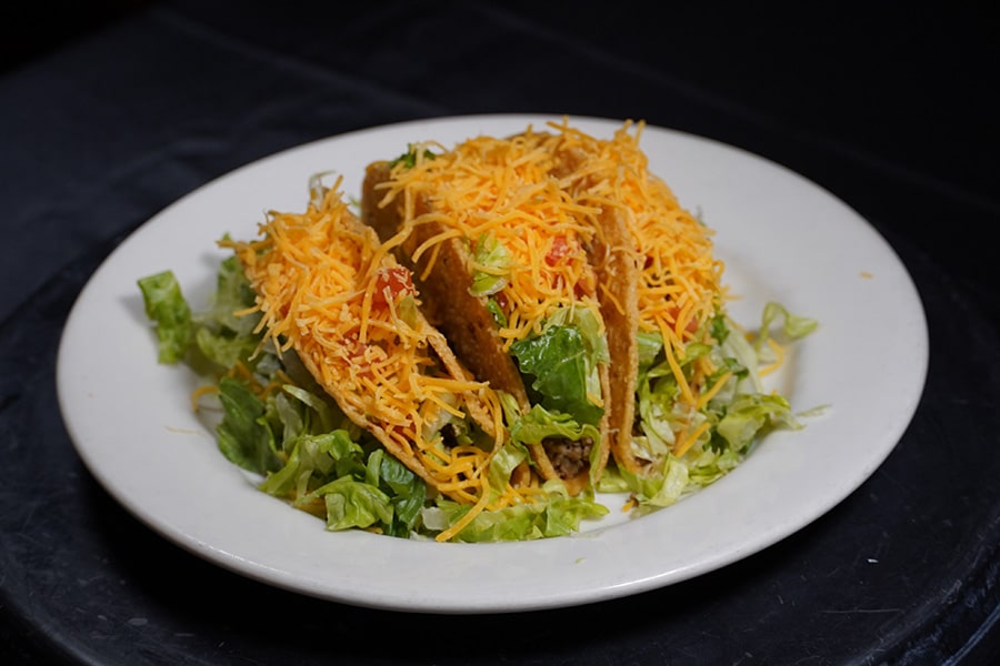 Plate of tacos with lettuce and cheese