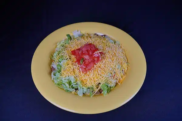 taco salad with cheese and tomatoes on top