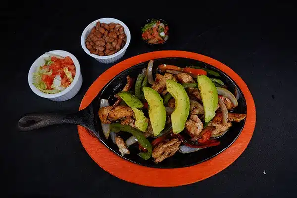Chicken fajitas with beans and salsa and avocado on top