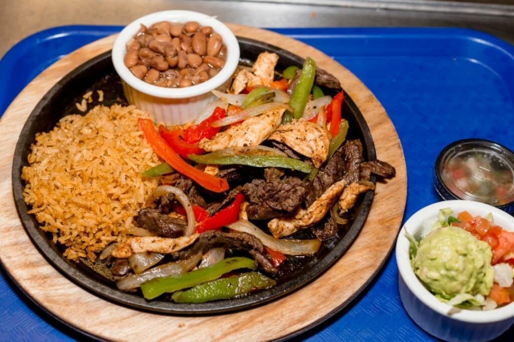 Chicken fajitas with rice, beans, and guacamole