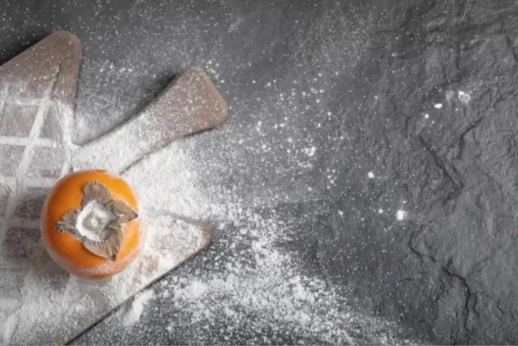 Persimmon on a floured cutting board