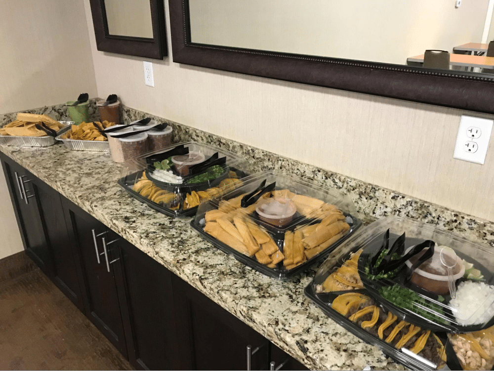 Tamales and chips buffet on a counter.