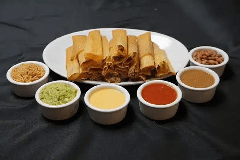 Plate of tamales with various sauces.