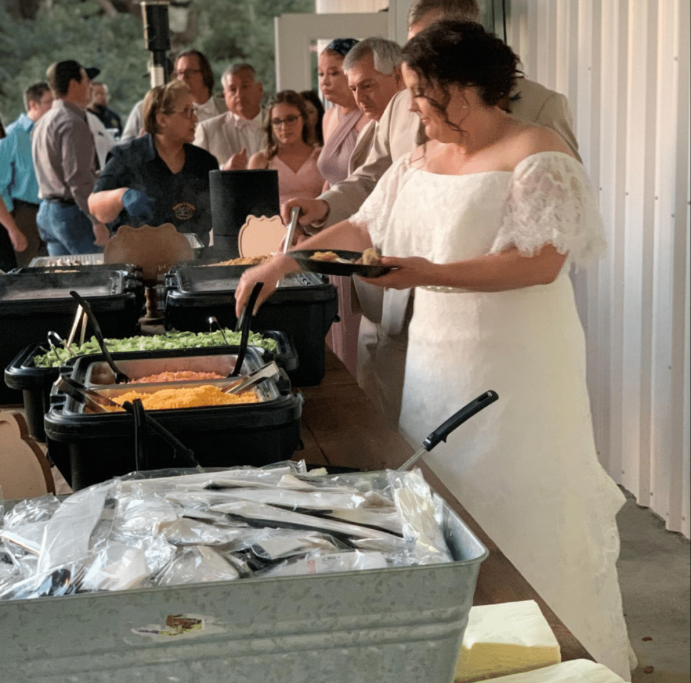 Bride serving herself at buffet table.