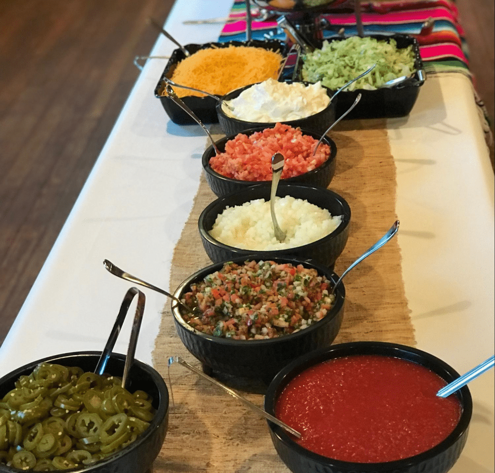 Toppings table with jalapeños, pico de gallo, and salsa.