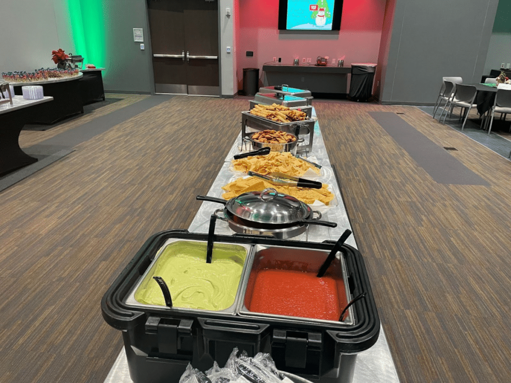 A wedding buffet featuring Tex-Mex dips like guacamole and salsa, surrounded by chips and festive dishes.