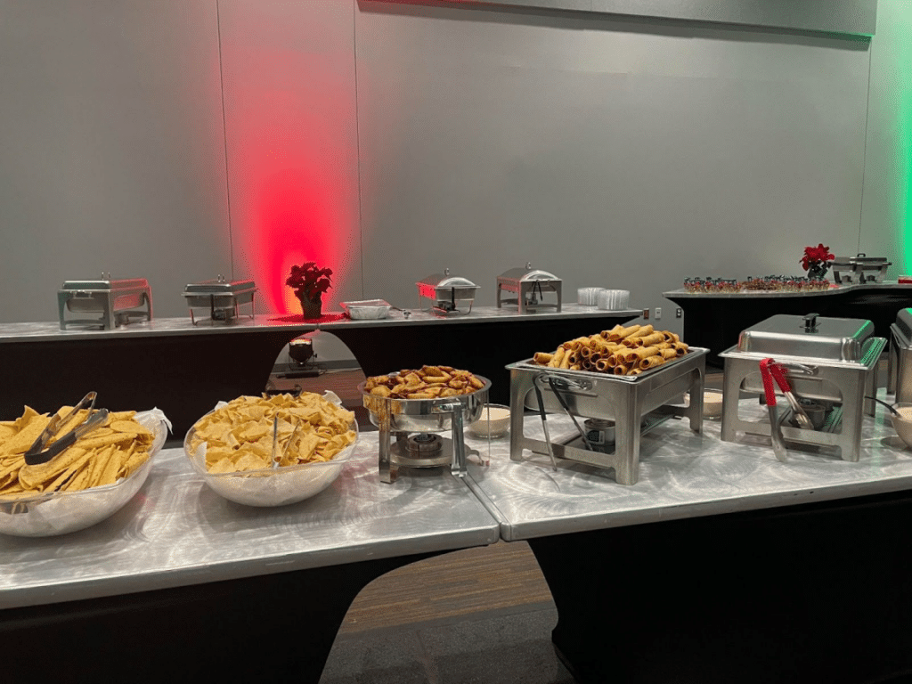 A taco bar with chips, rolled tacos, and other Tex-Mex foods served buffet-style.